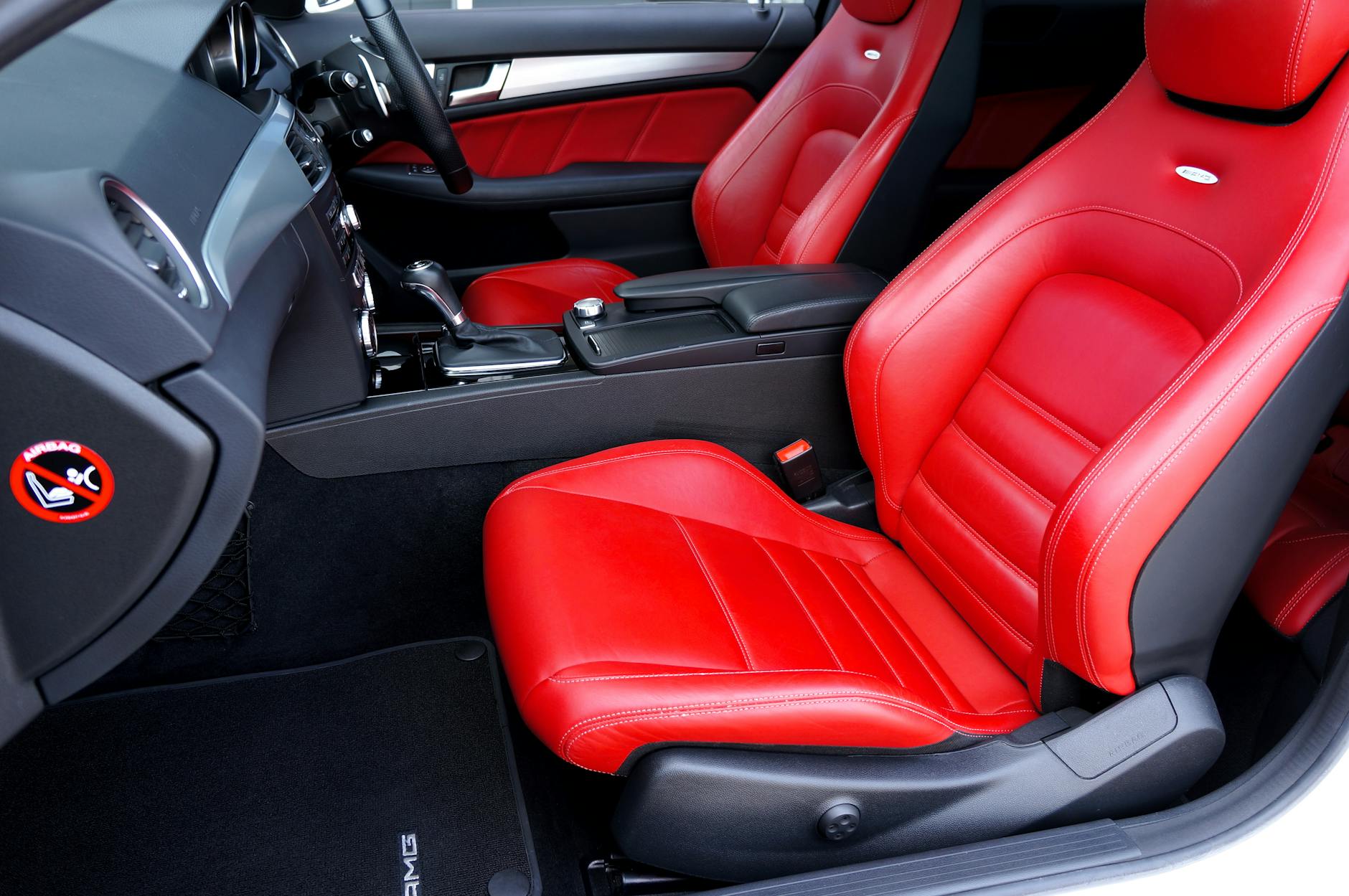 Wnętrze auta z czerwonymi skórzanymi siedzeniami i czystymi dywanikami