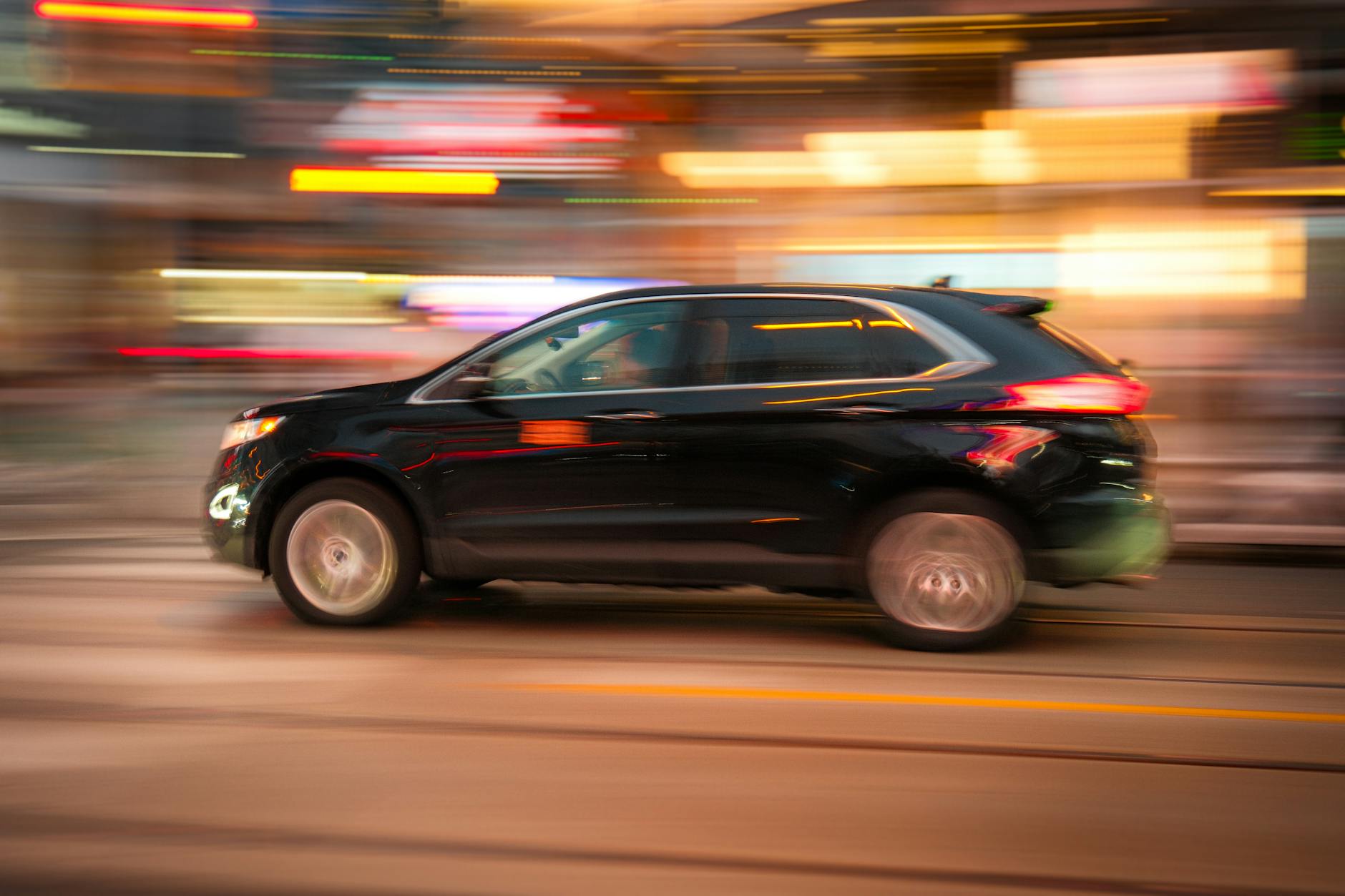 Czarny Hyundai Tucson Hybrid jedzie ulicą w nowoczesnym mieście