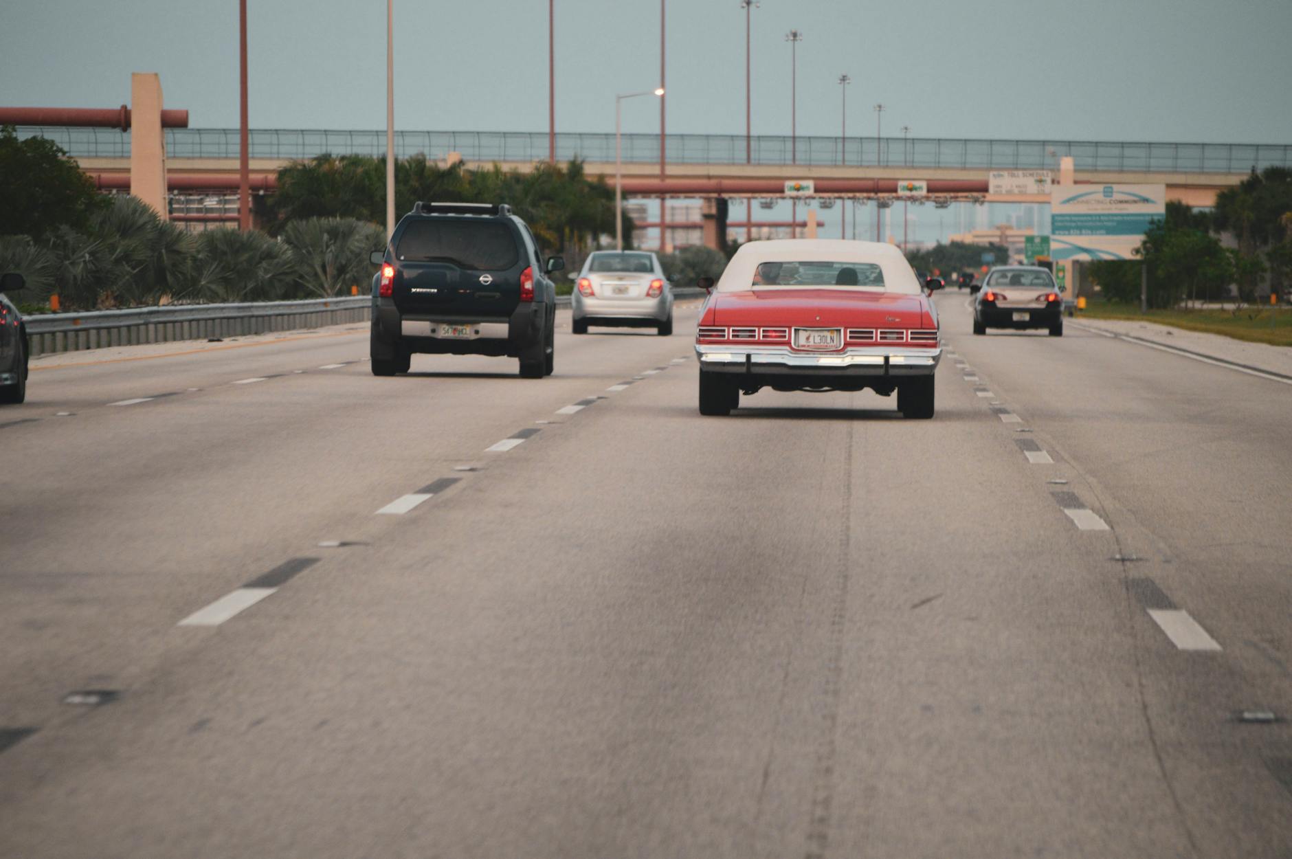 Czy warto inwestować w dodatkowe wyciszenie drzwi i nadkoli, jeśli często jeździsz autostradą? Klasyczny samochód na autostradzie w miejskim ruchu Miami