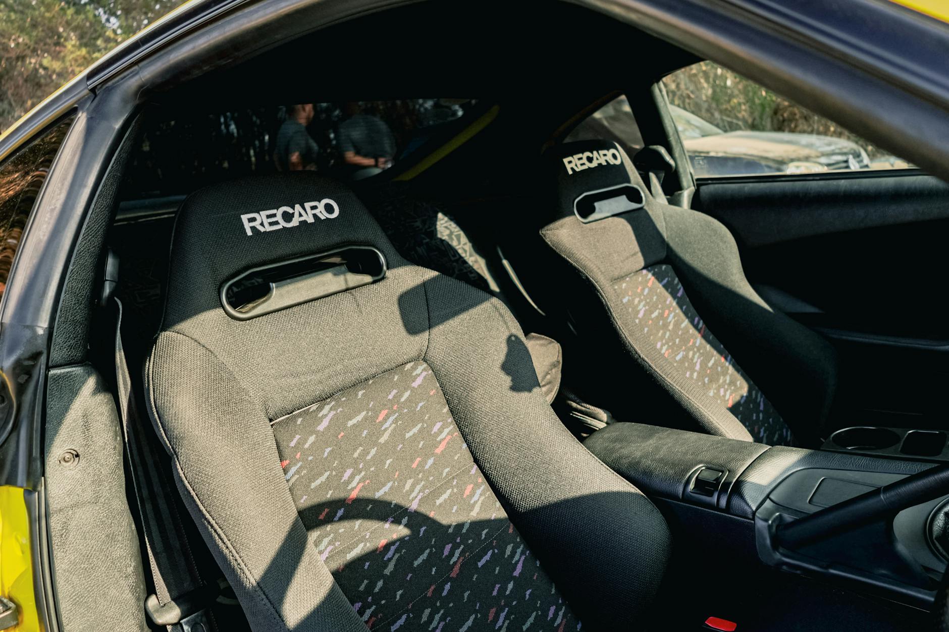 Wnętrze żółtego sportowego auta z kubełkowymi fotelami Recaro