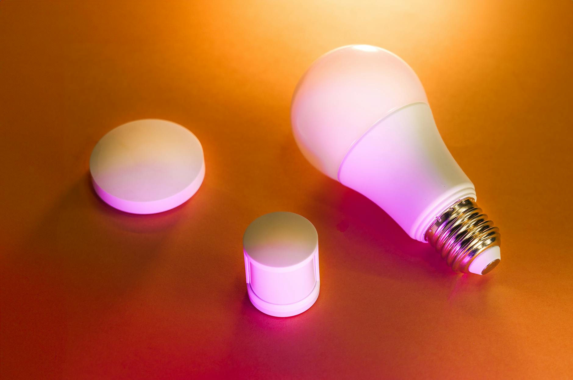 Inteligentna żarówka LED i akcesoria na pomarańczowym tle